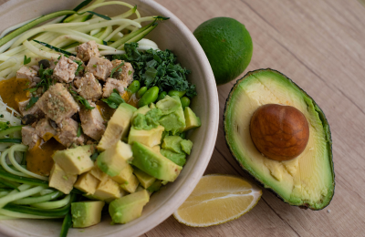 Avocado halves and leafy green salad with olive oil