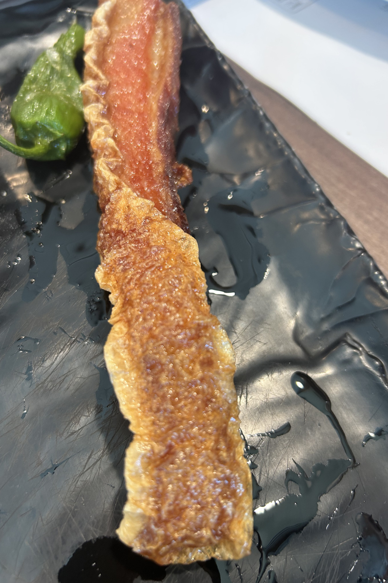 Grass-fed steak cooked rare on a wooden board with herbs
